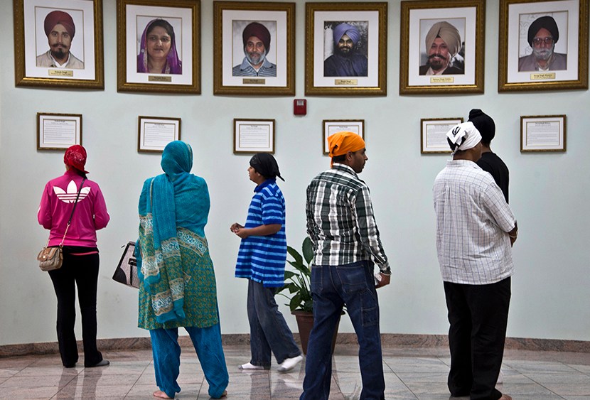 Visitors look at a memorial near the entrance of the Sikh Temple of Wisconsin Wednesday, July 31, 2013, in Oak Creek, Wis. Twelve months ago a white supremacist shot and killed six temple members, and the survivors plan to mark the one-year anniversary...