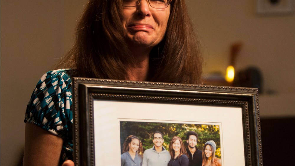 In this photo, taken, Friday, Sept. 12, 2014, shows Susan Hunt holding a photo of her family, including her son, Darrien Hunt, at her home in Saratoga Springs, Utah.