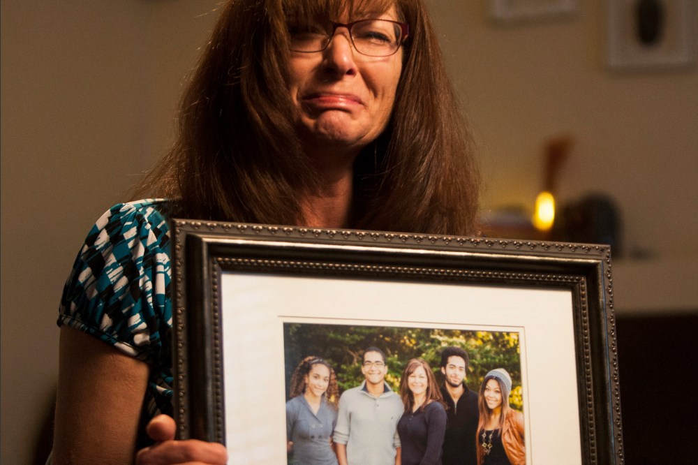 In this photo, taken, Friday, Sept. 12, 2014, shows Susan Hunt holding a photo of her family, including her son, Darrien Hunt, at her home in Saratoga Springs, Utah.