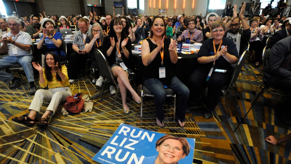 A "Run Liz Run" poster sits on the floor in front of LaNae Havens, center, as she cheers for Sen. Elizabeth Warren, D-Mass., at the Netroots Nation conference in Detroit, Mich., July 18, 2014.