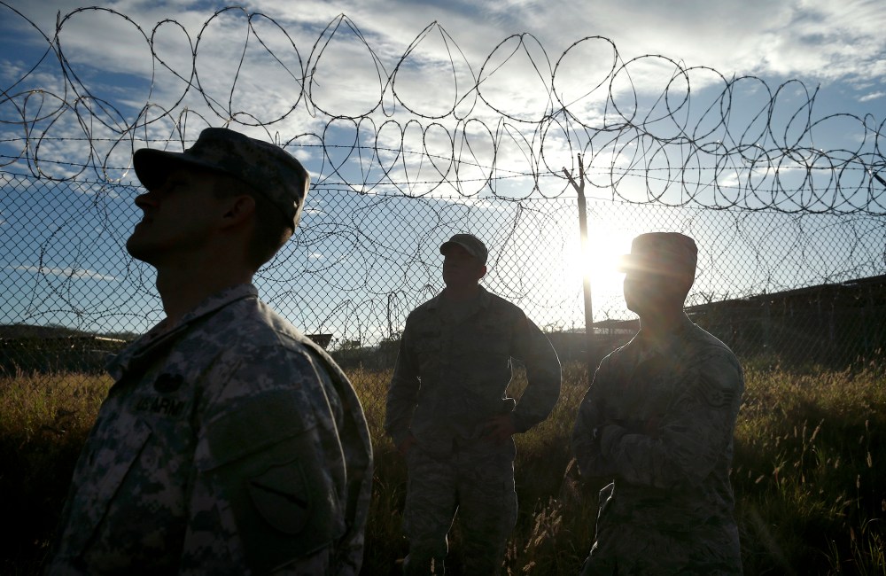 Military personnel walk in the now abandoned Camp X-Ray at Guantanamo Bay Naval Base, Cuba, Nov. 21, 2013.