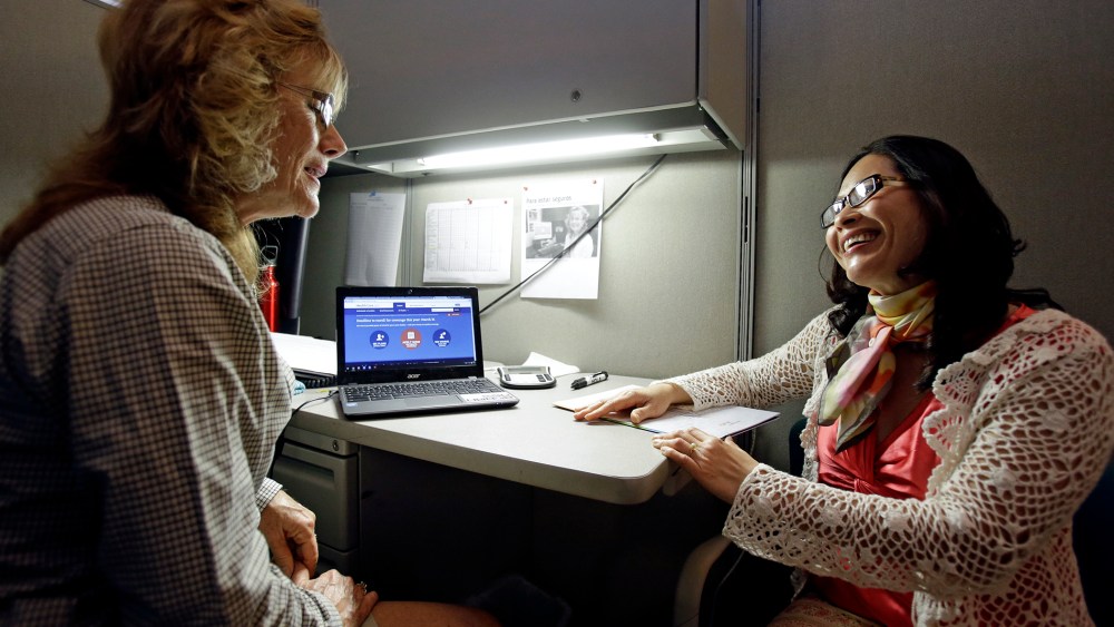 Elizabeth Hernandez, left, a navigator for the Affordable Care Act helps Giao Phan sign up for health insurance at the East Orange Community Center, on March 31, 2014, in Orlando, Fla.