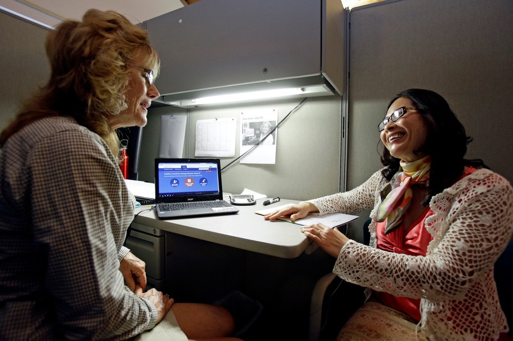 Elizabeth Hernandez, left, a navigator for the Affordable Care Act helps Giao Phan sign up for health insurance at the East Orange Community Center, on March 31, 2014, in Orlando, Fla.