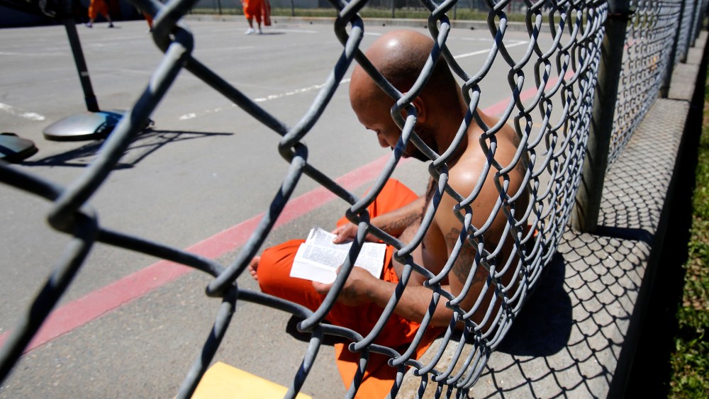 An inmate reads a Bible in the exercise yard of Sacramento County's Rio Cosumnes Correctional Center in Elk Grove, Calif. on May 30, 2013.