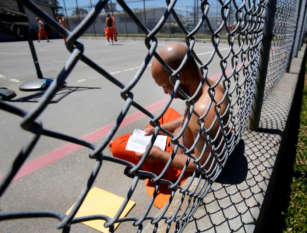 An inmate reads a Bible in the exercise yard of Sacramento County's Rio Cosumnes Correctional Center in Elk Grove, Calif. on May 30, 2013.