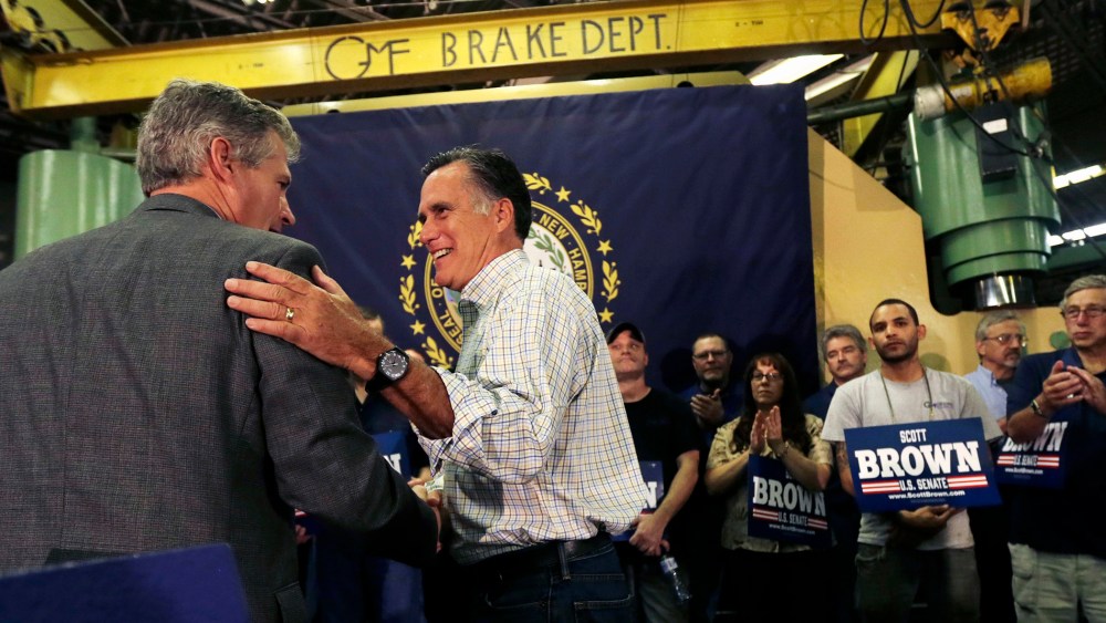 Former Republican Presidential candidate Mitt Romney gives New Hampshire Republican Senate candidate Scott Brown, left, a pat on the back during a campaign stop in Hudson, N.H. on Oct. 15, 2014.