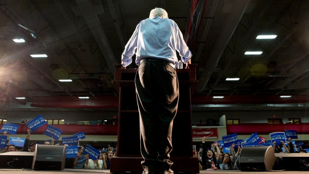 Having removed his suit jacket from the heat, Democratic presidential candidate Sen. Bernie Sanders, I-Vt., pauses as people cheer during a campaign rally at Milton High School in Milton, Mass., Feb. 29, 2016. (Photo by Jacquelyn Martin/AP)