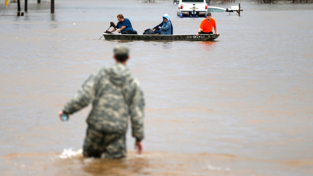 A Louisiana National Guardsman wades through water as residents are evacuated by boat through rising floodwaters in Bossier Parish, La., March 10, 2016. (Photo by Gerald Herbert/AP)