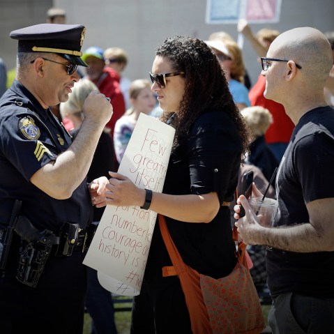 A police officer confronts a lady at the State Capitol in Raleigh, N.C., April 11, 2016, during a rally in support of a law that blocks rules allowing transgender people to use the bathroom aligned with their gender identity. (Photo by Gerry Broome/AP)