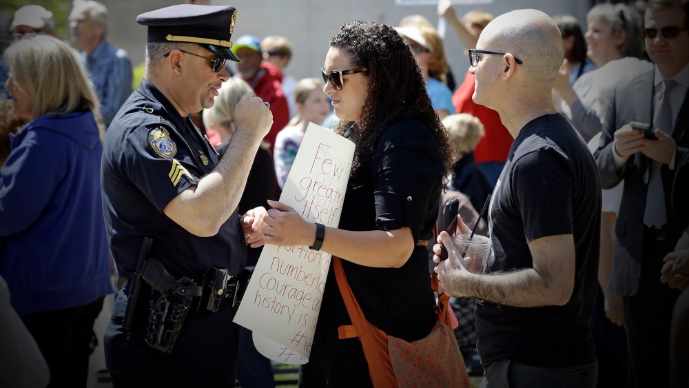 A police officer confronts a lady at the State Capitol in Raleigh, N.C., April 11, 2016, during a rally in support of a law that blocks rules allowing transgender people to use the bathroom aligned with their gender identity. (Photo by Gerry Broome/AP)