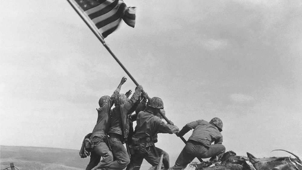 U.S. Marines of the 28th Regiment, 5th Division, raise the American flag atop Mt. Suribachi, Iwo Jima, Japan, Feb. 23, 1945. (Photo by Joe Rosenthal/AP)