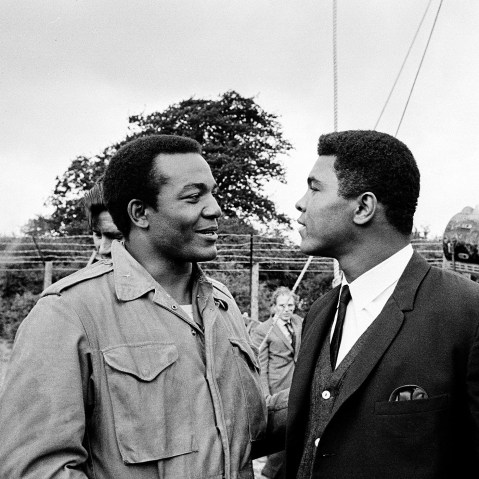 In this Aug. 5, 1966 photo, heavyweight boxer Muhammad Ali, right, visits Cleveland Browns running back and actor Jim Brown on the film set of "The Dirty Dozen" at Morkyate, Bedfordshire, England.