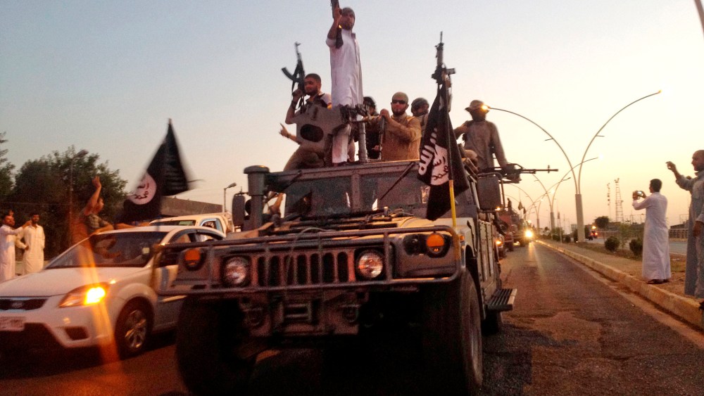 In this June 23, 2014 photo, fighters from the Islamic State group parade in a commandeered Iraqi security forces armored vehicle down a main road at the northern city of Mosul, Iraq. (Photo by AP)
