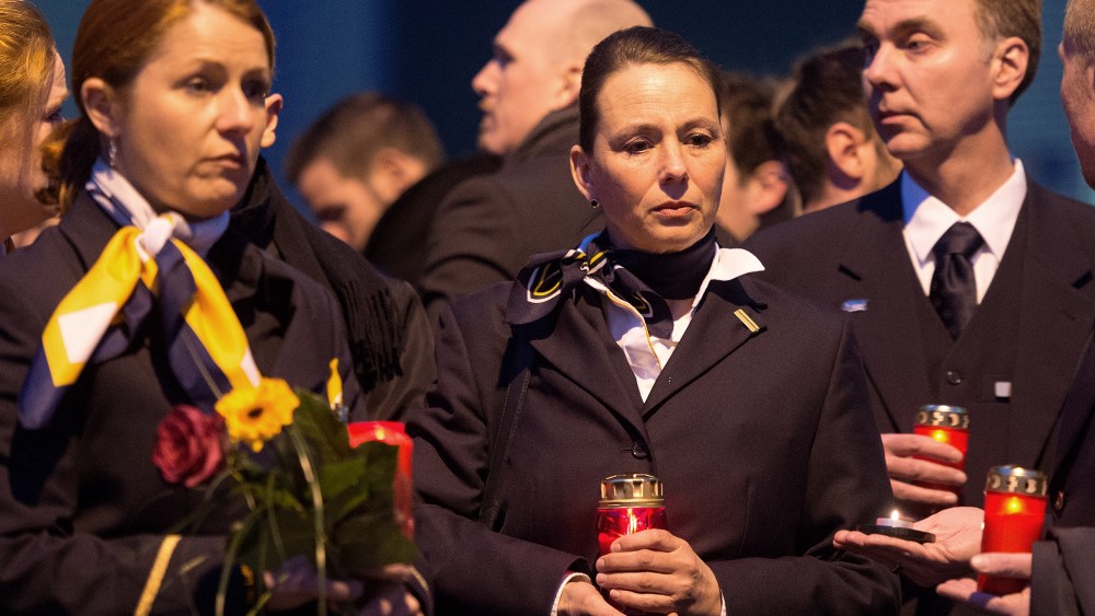 Staff members of Germanwings and Lufthansa stand in front of the headquarter of air carrier Germanwings placing flowers and candles at the main entrance in Cologne, Germany, March 24, 2015. (Photo by Marius Becker/picture-alliance/dpa/AP)