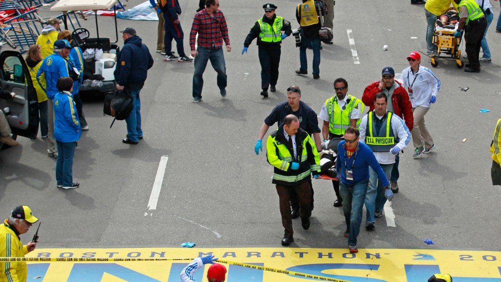 Medical workers wheel the injured across the finish line during the 2013 Boston Marathon following an explosion in Boston, Monday, April 15, 2013. (Photo by Charles Krupa/AP Photo)
