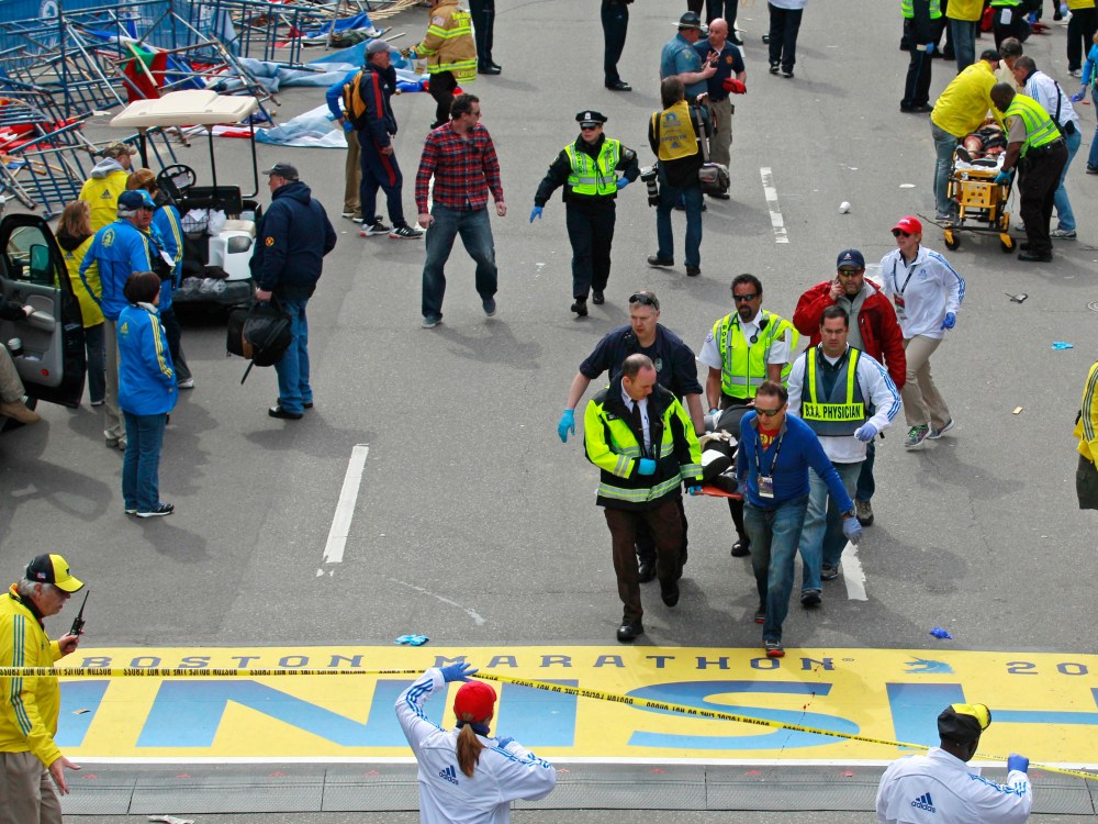 Medical workers wheel the injured across the finish line during the 2013 Boston Marathon following an explosion in Boston, Monday, April 15, 2013. (Photo by Charles Krupa/AP Photo)