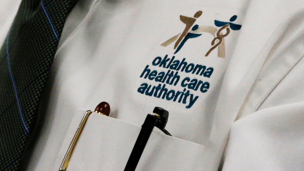 An audience member wears an Oklahoma Health Care Authority shirt during an OHCA board meeting in Oklahoma City, July 1, 2014.