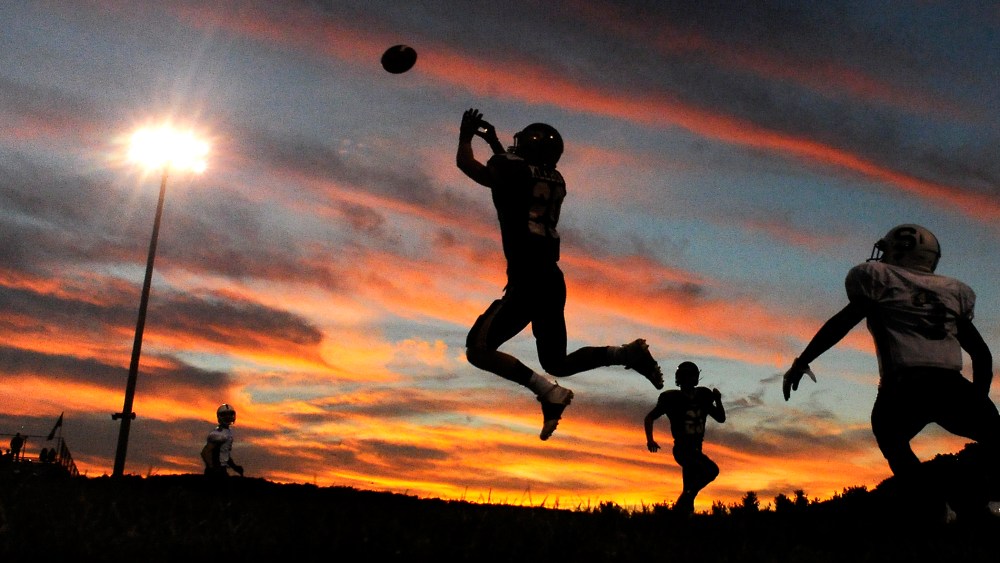 A player jumps to intercept a pass during a high school football game. (Photo by Jimmy May/Bloomsburg Press Enterprise/AP)