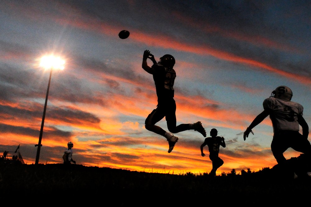 A player jumps to intercept a pass during a high school football game. (Photo by Jimmy May/Bloomsburg Press Enterprise/AP)