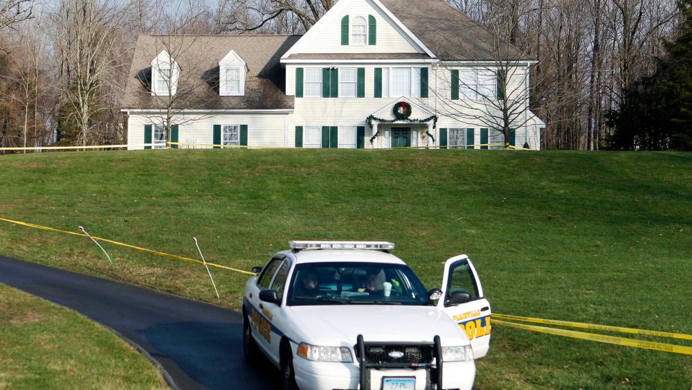 In this Dec. 18, 2012, file photo, a police cruiser sits in the driveway of the home of Nancy Lanza in Newtown, Conn., the Colonial-style house where she had lived with her son Adam Lanza. (Photo by Jason DeCrow/AP)
