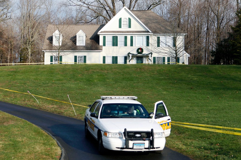 In this Dec. 18, 2012, file photo, a police cruiser sits in the driveway of the home of Nancy Lanza in Newtown, Conn., the Colonial-style house where she had lived with her son Adam Lanza. (Photo by Jason DeCrow/AP)