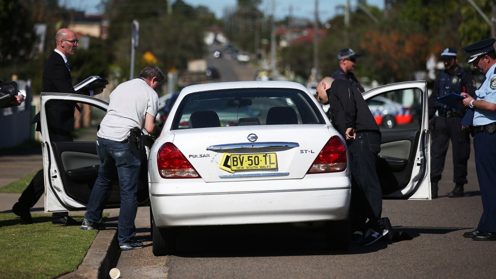 Police investigators search a car at a home at Guildford in suburban Sydney, Sept. 18, 2014.