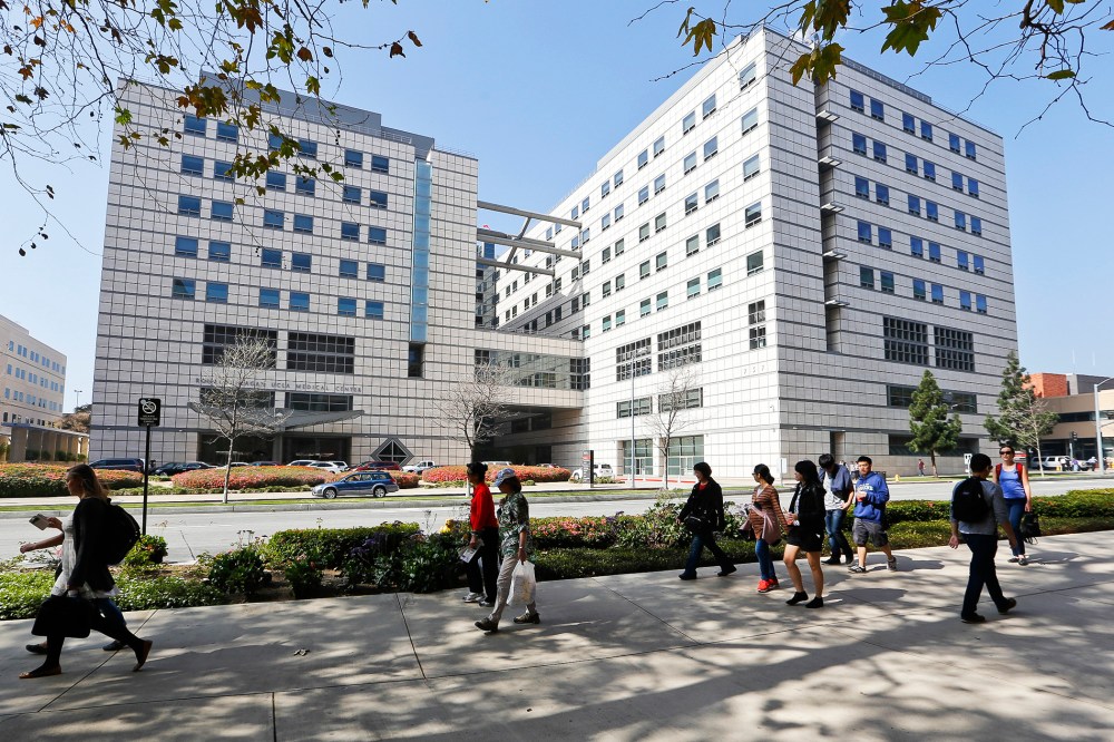 People walk near the Ronald Reagan UCLA Medical Center in Los Angeles building in Los Angeles, Calif., Feb. 19, 2015. (Photo by Damian Dovarganes/AP)