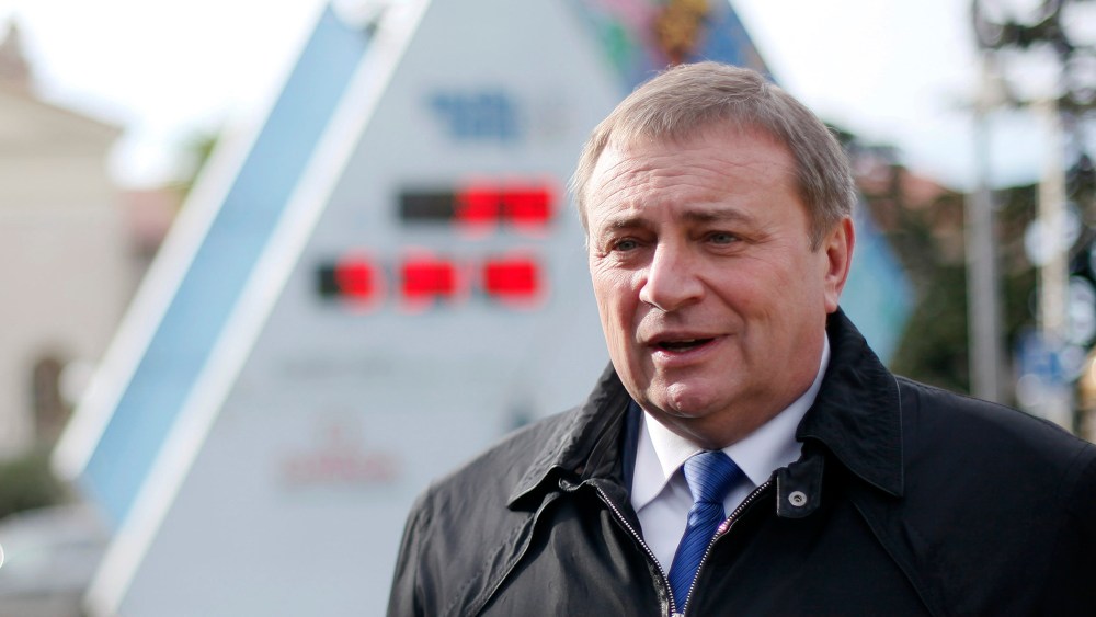 Sochi's Mayor Anatoly Pakhomov stands with the count-down clock to the Olympics on Jan. 31, 2013.