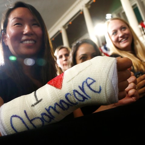 Cathey Park from Cambridge, Mass. shows the words "I Love Obamacare" on her cast for her broken wrist Faneuil Hall in Boston on Oct. 30, 2013.