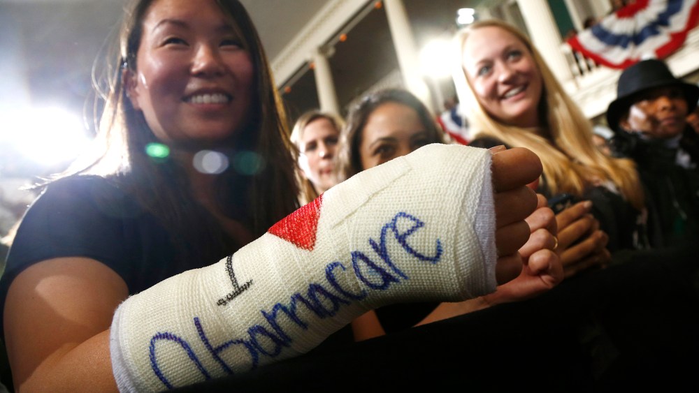Cathey Park from Cambridge, Mass. shows the words "I Love Obamacare" on her cast for her broken wrist Faneuil Hall in Boston on Oct. 30, 2013.