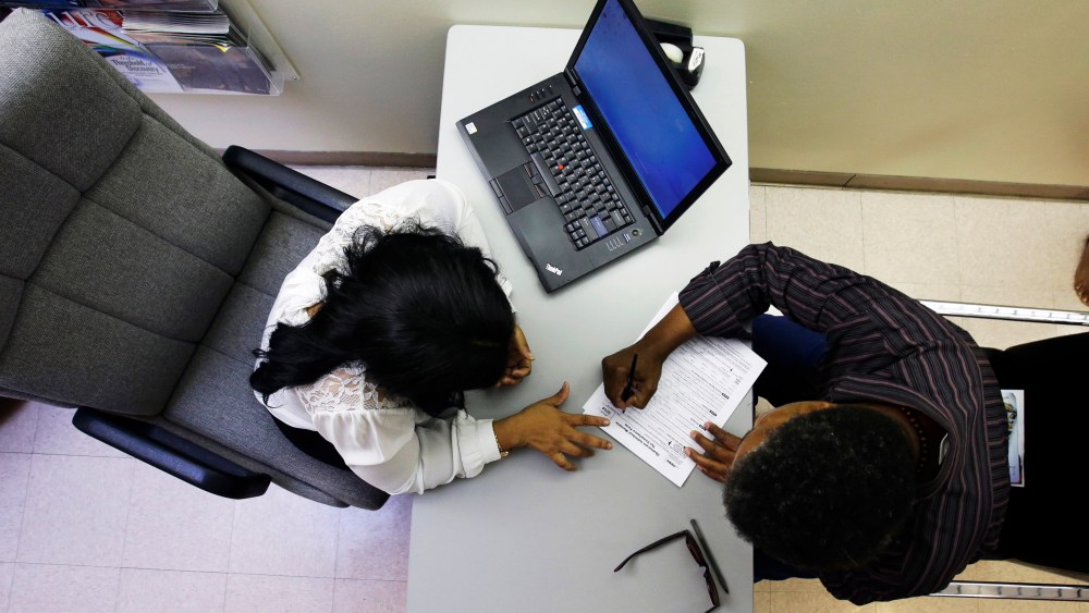 Clinical applications counselor Rachael Richardson works with Louis Peters at the Henry J. Austin Health Center, in Trenton, N.J., as he and others fill out papers to sign up for new plans through a health insurance exchange, Oct. 1, 2013.