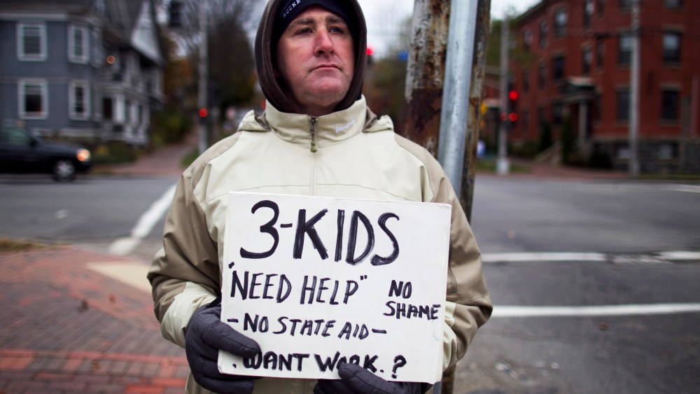 Brian Adams, 42, stands on the corner of State Street and Park Avenue, in Portland, Maine, Wednesday, Nov. 7, 2012. Adams, who lives with his fiance and their three children on Munjoy Hill, lost his job as a mason.