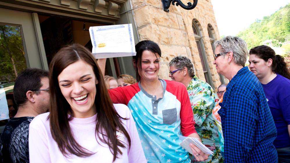 Kristin Seaton, of Jacksonville, Ark., holds up her marriage license as she leaves the Carroll County Courthouse in Eureka Springs, Ark., with her partner, Jennifer Rambo, May 10, 2014.