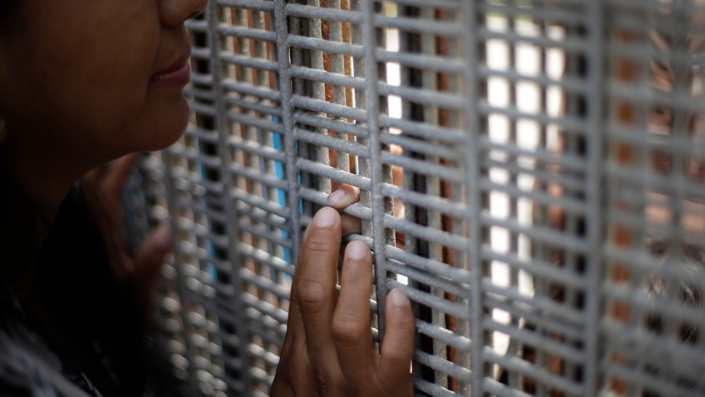 Marta Lopez touches the finger of her daughter Alondra Lopez, 8, as they stand separated by a fence between Tijuana, Mexico, and San Diego on July 14, 2013.