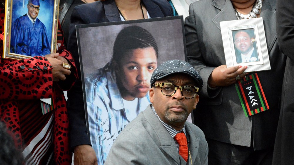 Filmmaker Spike Lee appears at a news conference, May 14, 2015 in Chicago, flanked by parents holding photographs of the children they've lost to gun violence in Chicago. (Photo by Brian Jackson/Sun-Times Media/AP)