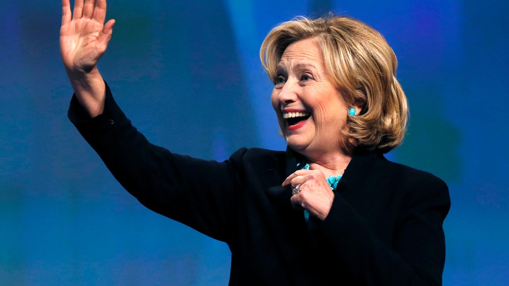 Former Secretary of State Hillary Rodham Clinton waves as she is introduced at an event in Boston, Mass., Dec. 4, 2014. (Photo by Elise Amendola/AP)