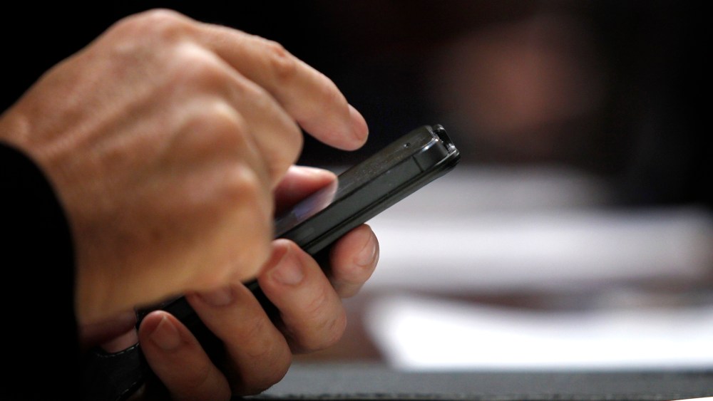 A Spanish lawmaker uses his cell phone in Madrid on Oct. 30, 2013.