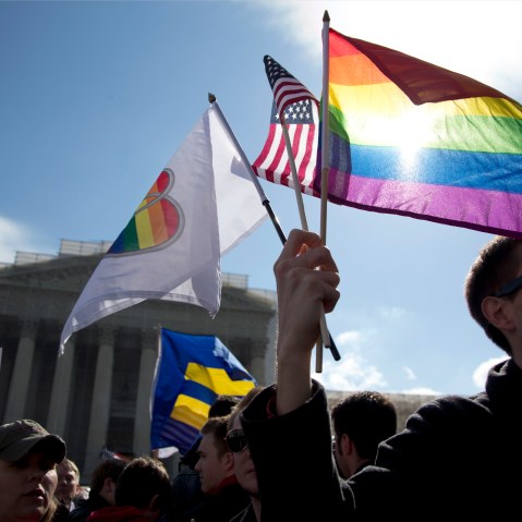 Kevin Coyne of Washington holds flags in front of the Supreme Court in Washington. (Photo by Carolyn Kaster/AP)