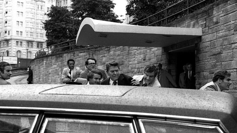 U.S. President Ronald Reagan is shoved into his limousine after being shot outside a Washington hotel, March 30, 1981. Secret service agent Jerry Parr, to the right of Reagan, was credited with saving the president's life. (Photo by Ron Edmonds/AP)
