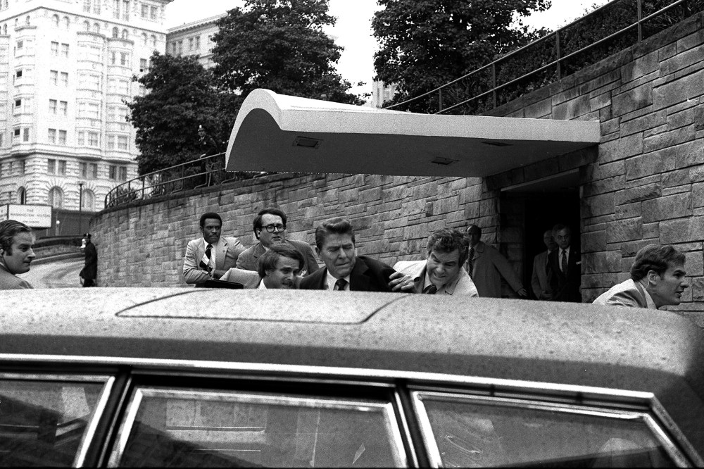 U.S. President Ronald Reagan is shoved into his limousine after being shot outside a Washington hotel, March 30, 1981. Secret service agent Jerry Parr, to the right of Reagan, was credited with saving the president's life. (Photo by Ron Edmonds/AP)