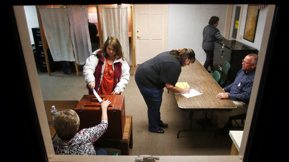 Voters cast their ballots and sign petitions at the polling place in town hall in Knox, Maine on Nov. 4, 2014.