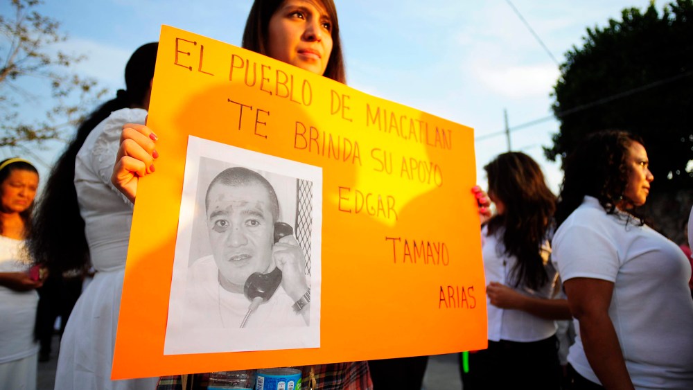 A woman holds up a sign that reads "The town of Miacatlan offers you our support, Edgar Tamayo Arias" during a protest demanding Tamayo's pardon, Jan. 19, 2014.