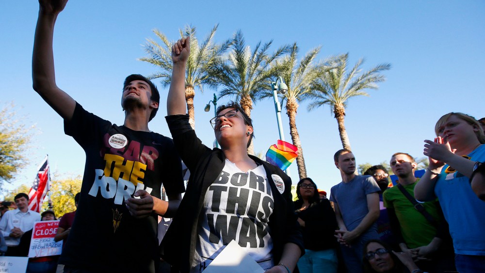 Anthony Musa, left, and Brianna Pantillione join nearly 250 gay rights supporters protesting SB1062 at the Arizona Capitol, Friday, Feb. 21, 2014, in Phoenix.