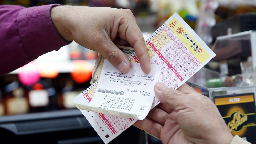 Money and Powerball tickets change hands at Pine Liquors in Fort Washington, Md., Jan. 8, 2016, for the upcoming Powerball drawing. (Photo by Alex Brandon/AP)