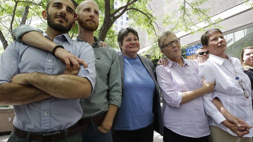 In this June 25, 2014 file photo, from left, plaintiffs Moudi Sbeity and Derek Kitchen, Kate Call, Laurie Wood and Kody Partridge, five of the six people who brought the lawsuit against the Utah's gay marriage ban, stand together at a news conference outs
