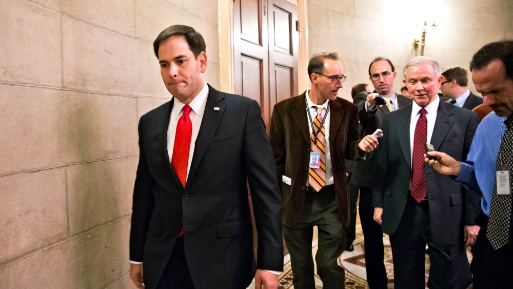 Sen. Marco Rubio passes as Sen. Jeff Sessions talks with reporters on Capitol Hill in Washington, Friday, Oct. 11, 2013.