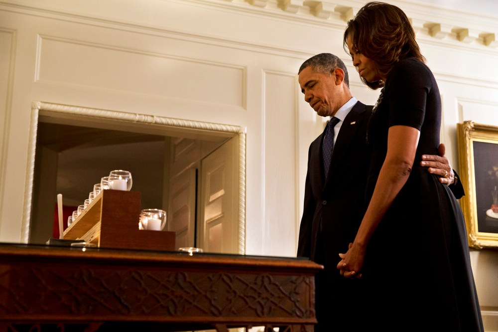 President Barack Obama and first lady Michelle Obama take a moment of silence in honor of the Newtown shooting victims on the one year anniversary of the tragedy, at the White House in Washington, Dec. 14, 2013.