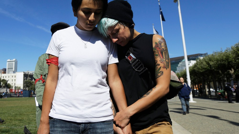Gabriela Serrano, 21, left, and A.J. James, 27, listen to a prayer during a vigil for Michael Brown of Ferguson, Mo., in San Francisco, Thursday, Aug. 14, 2014.