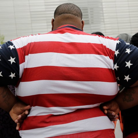 An overweight man wears a shirt patterned after the American flag during a visit to the World Trade Center, May 8, 2014 in New York. (Photo by Mark Lennihan/AP)