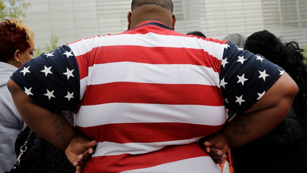 An overweight man wears a shirt patterned after the American flag during a visit to the World Trade Center, May 8, 2014 in New York. (Photo by Mark Lennihan/AP)